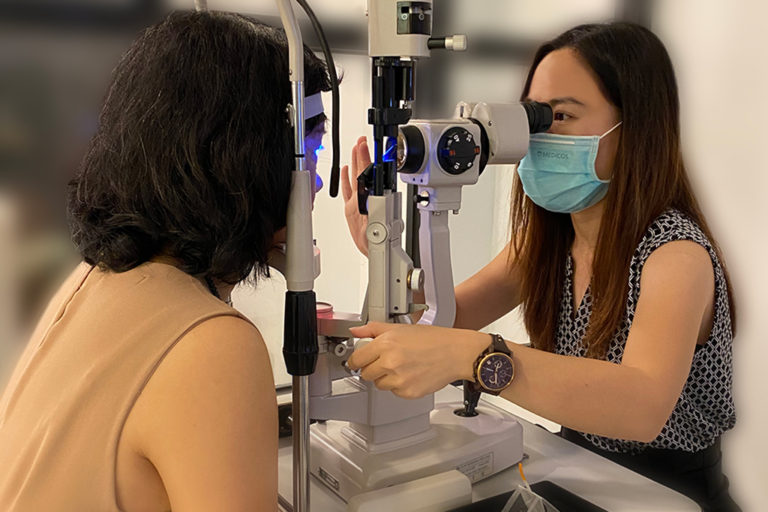 An optometrist performing a comprehensive eye examination to a lady.